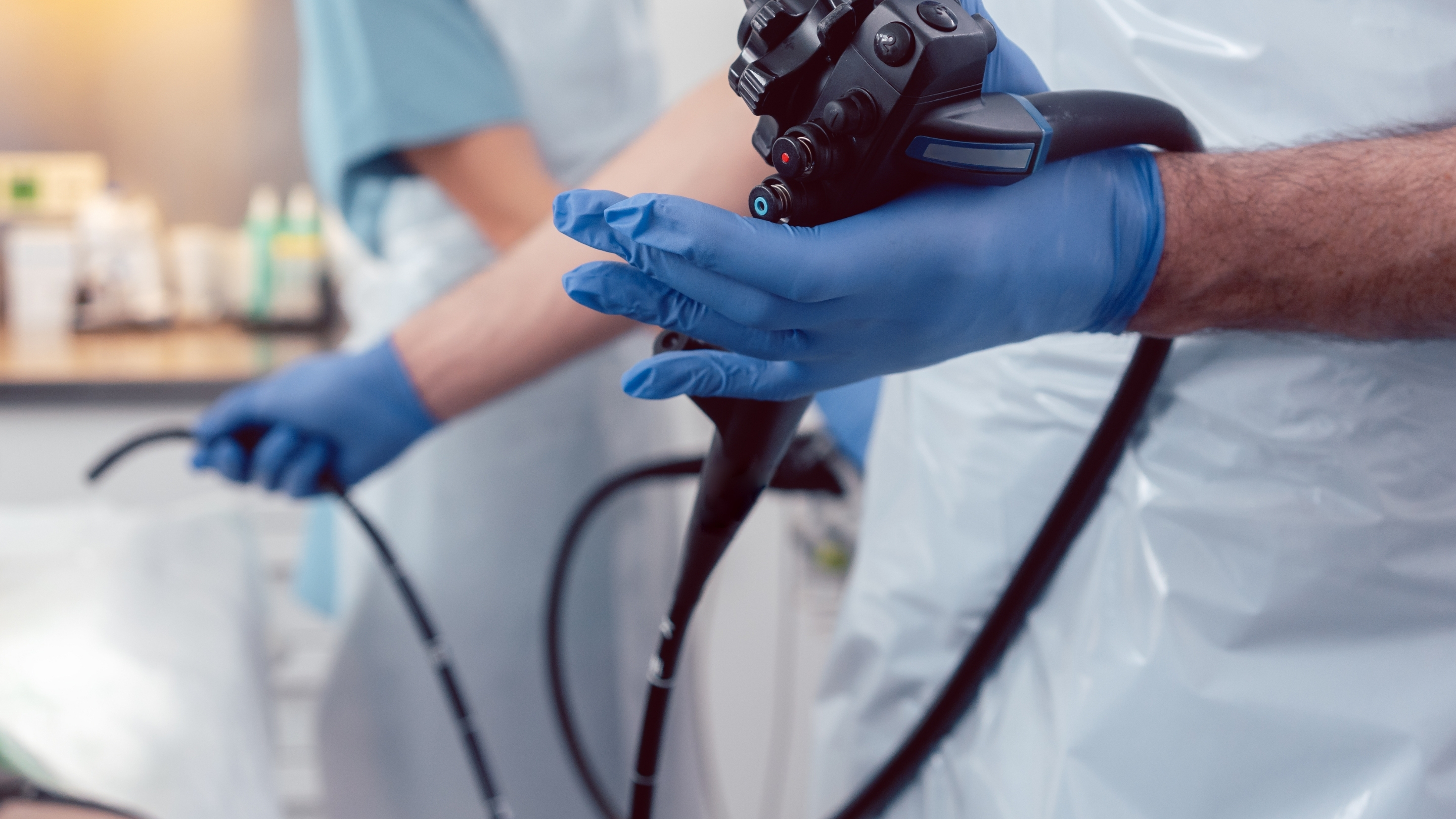 Clinicians handling an endoscope during reprocessing