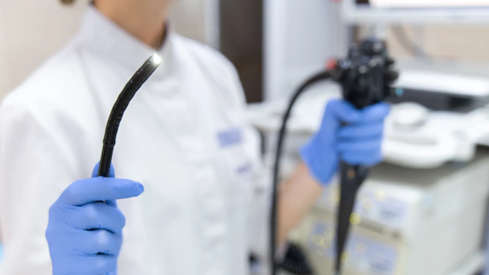 A clinician inspecting the illuminated tip of a flexible endoscope