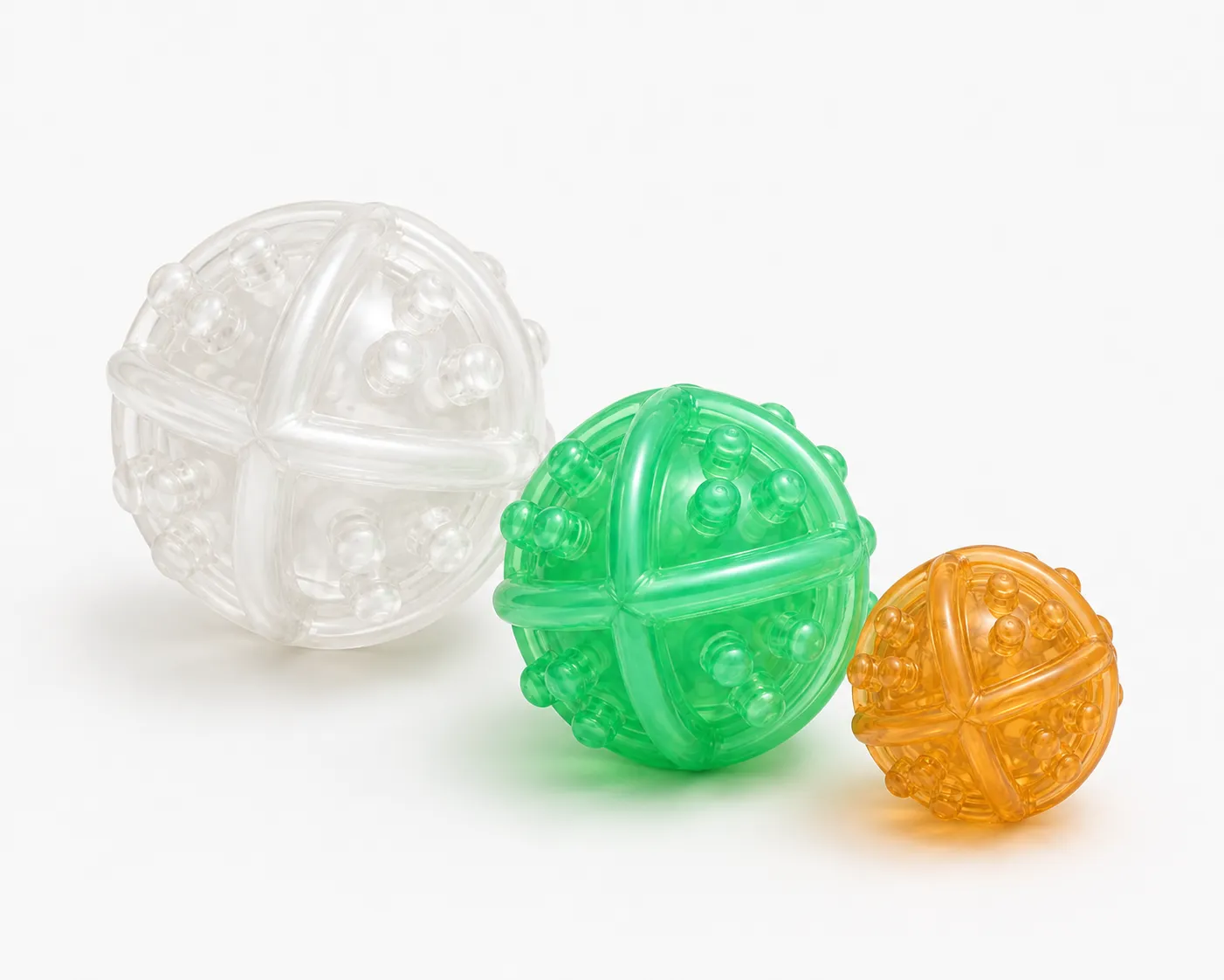 Three Nolan Balls in clear, green, and amber material